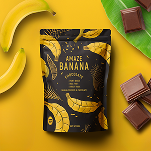 Black standing pouch mockup with gold banana illustrations, surrounded by fresh bananas and chocolate pieces on a yellow background.